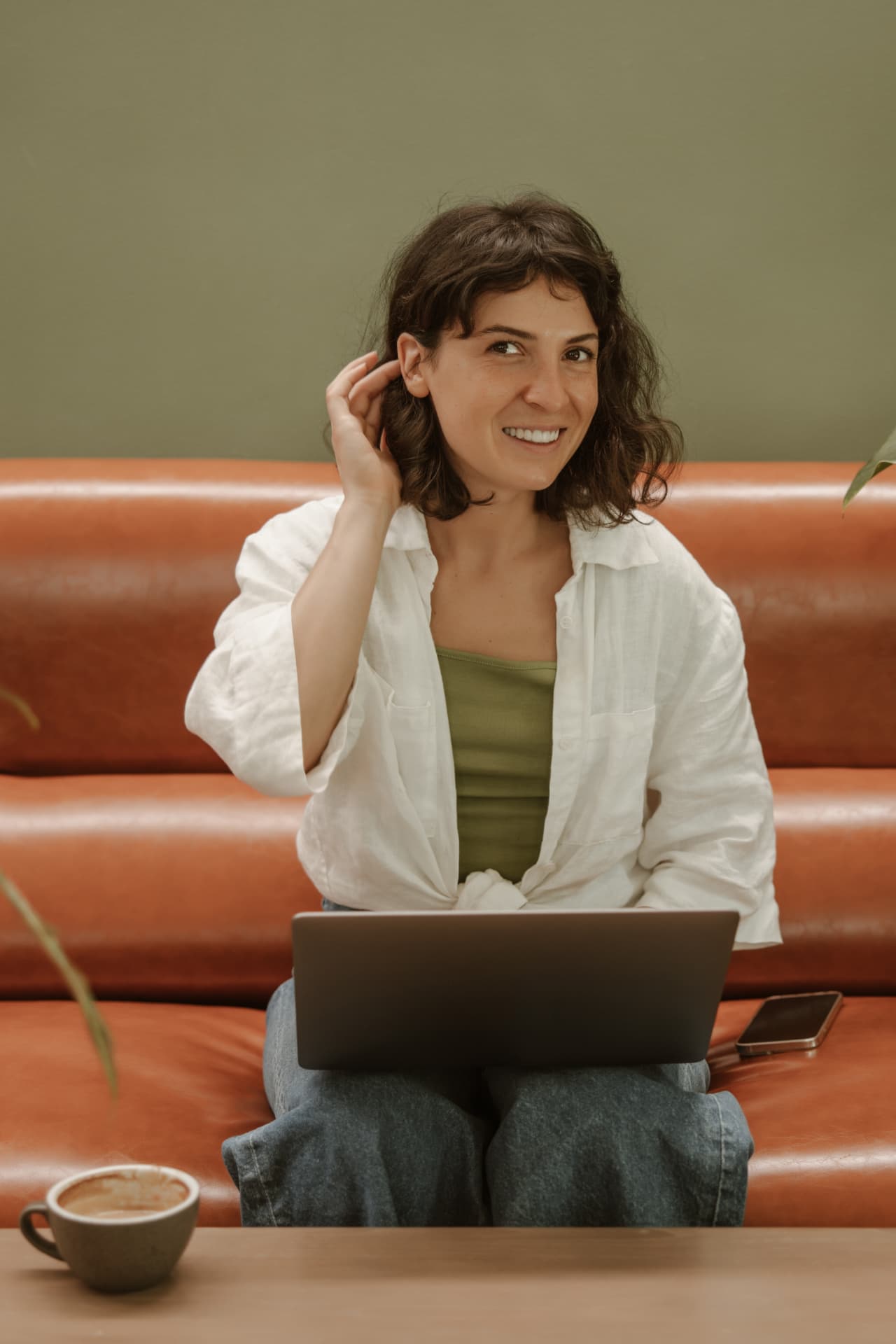 A poised woman working on a laptop at home