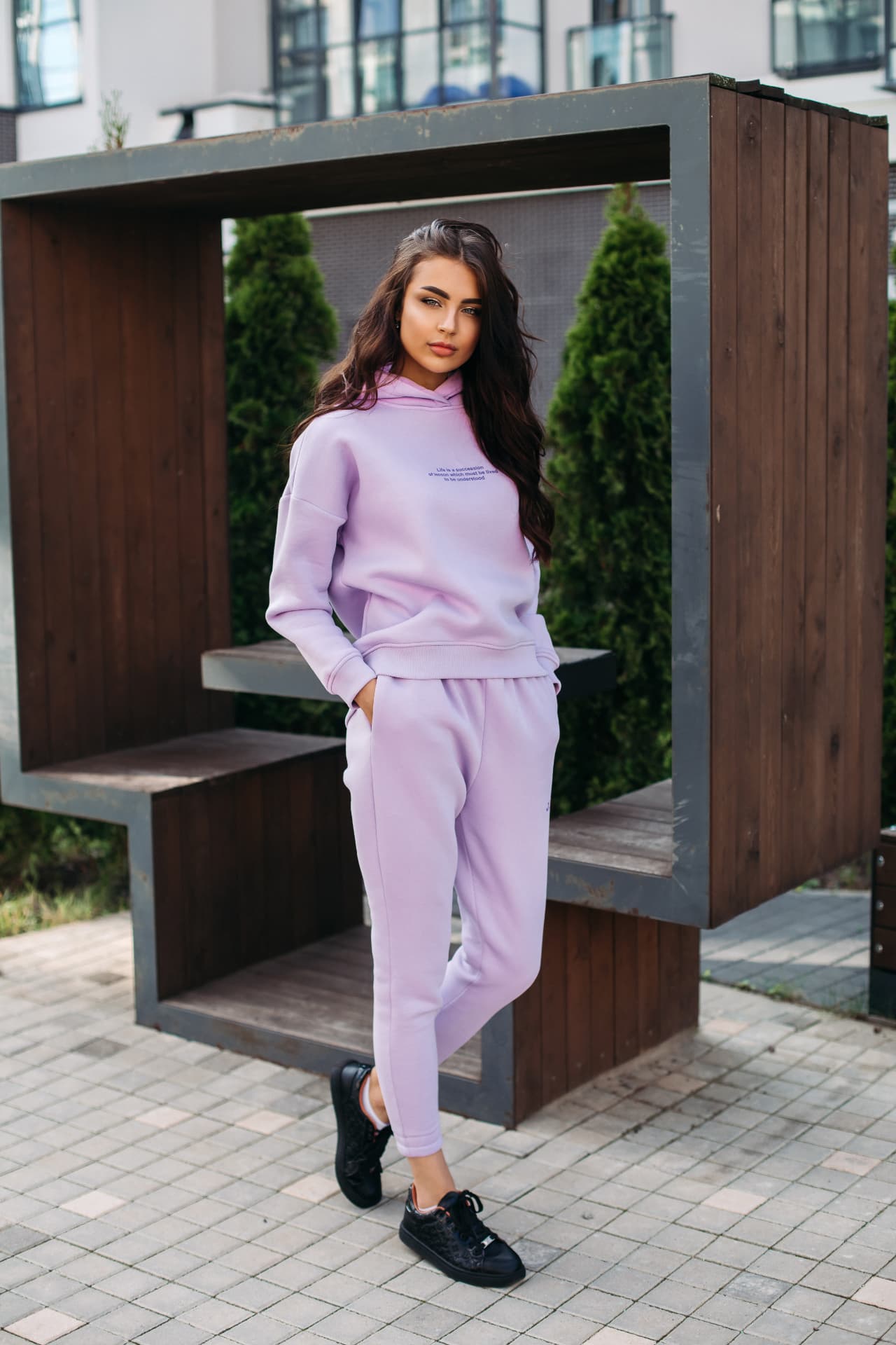 A young woman in a lilac outfit standing outdoors